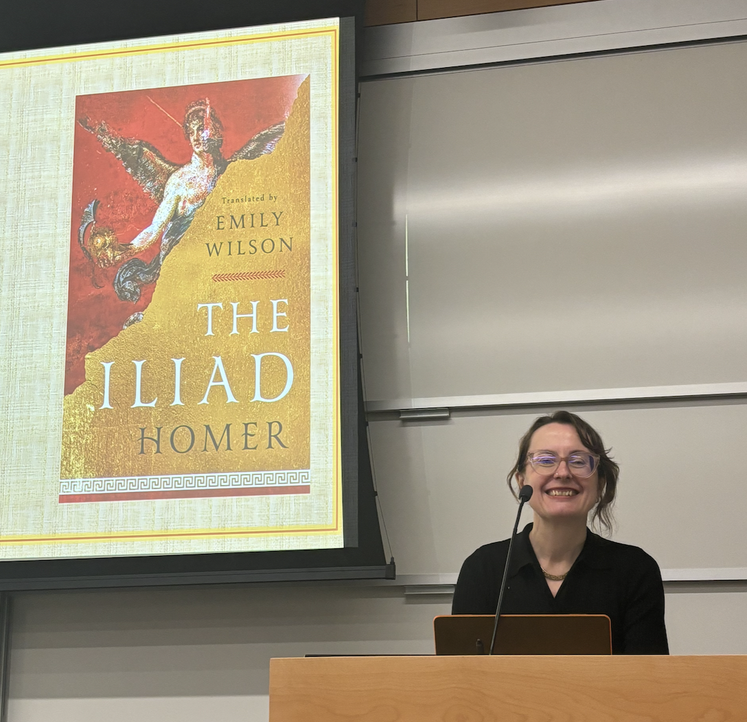 Emily Wilson smiles form behind podium.